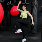 Mujer levantando pesas en el gimnasio con el Tank Top Verde Eco R3volution de RED FUTURO
